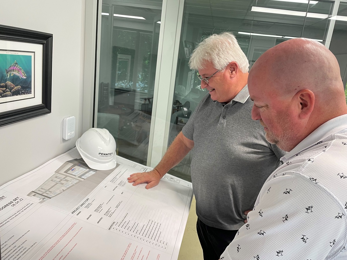 two penntex employees in office reviewing plans
