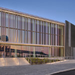 view of large window wall of life sciences building with reflection of surrounding landscape in view