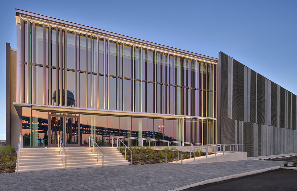 view of large window wall of life sciences building with reflection of surrounding landscape in view