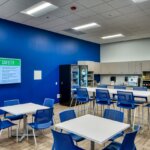 breakroom with tables, chairs and a kitchen
