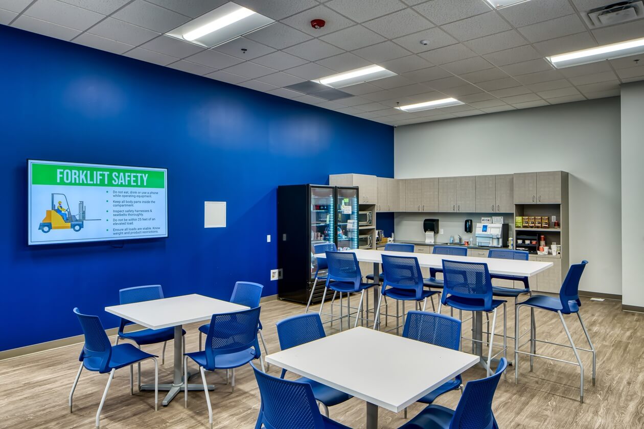 breakroom with tables, chairs and a kitchen