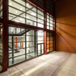 Unique warehouse entrance with large window walls view to interior stairs