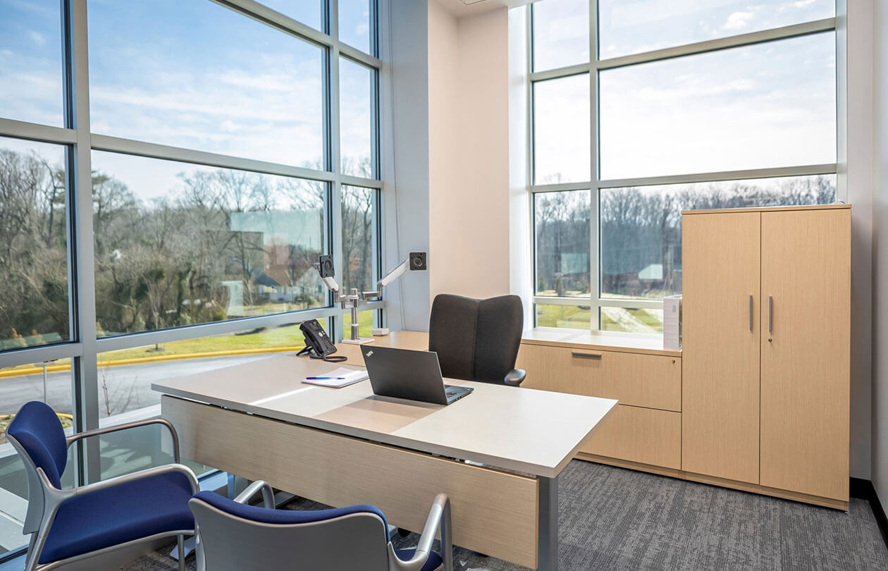 office view with desk and chairs looking out the window