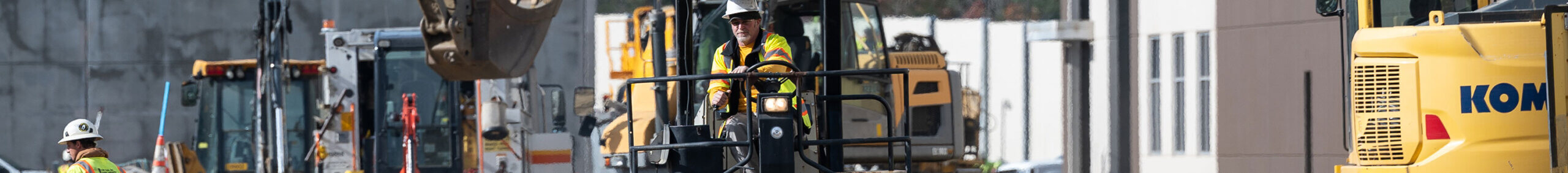 construction worker on large equipment at jobsite contact scaled