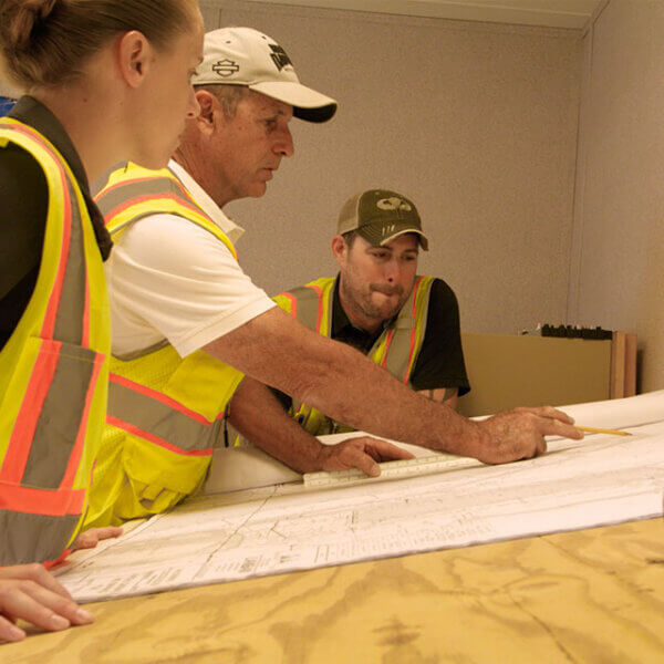 penntex employees reviewing project blueprints photo bar