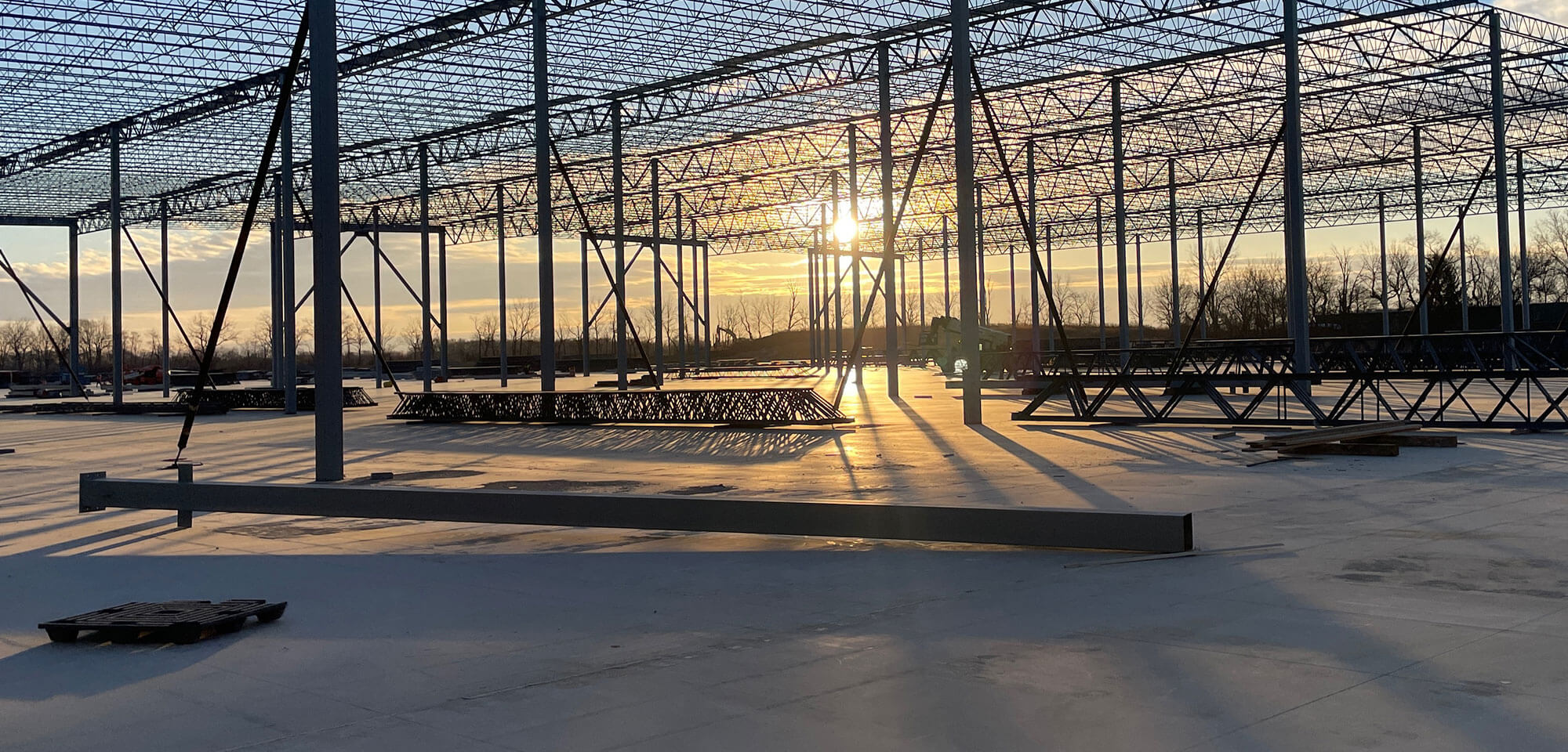 steel beams with sun setting in background