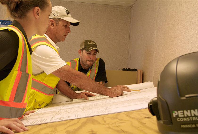 team members reviewing construction blueprints together