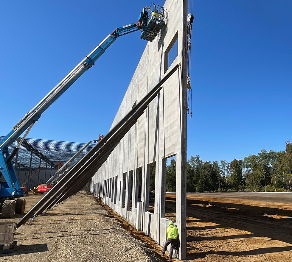 construction worker using crane on tilt wall