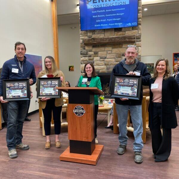 Group of individuals at a press conference holding plaques