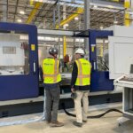 Penntex Team Members on Production Floor Looking at Equipment